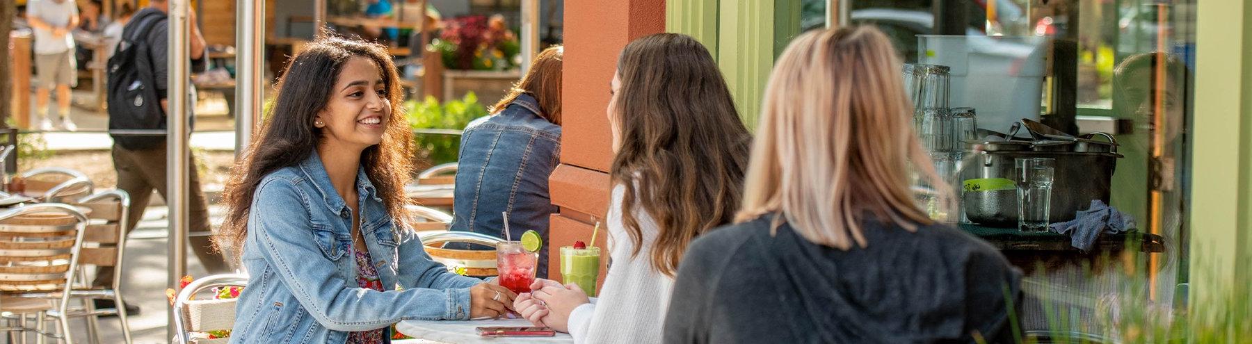 Student talks with friends at a cafe